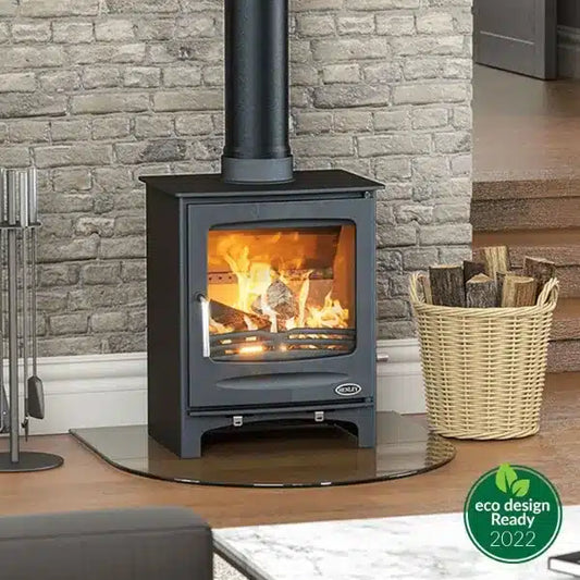 Henley Stoves Sherwood 7kW Multi Fuel Eco stove with roaring fire, displayed on hearth with log basket